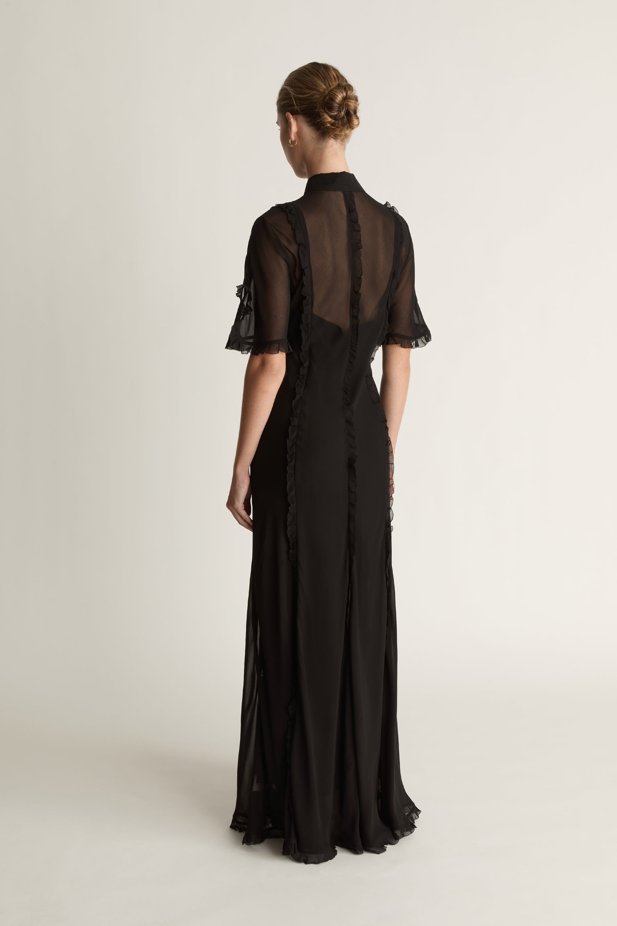 Black dress with sheer sleeves on a white background