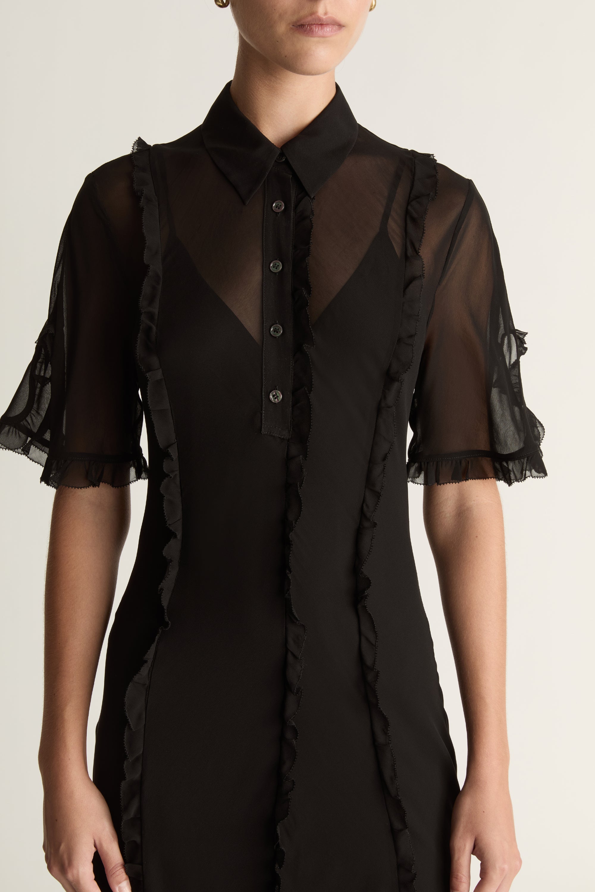 Black dress with sheer sleeves on a white background