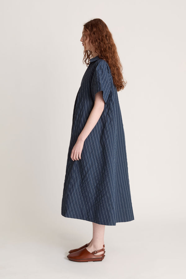 Woman wearing a blue striped dress on a white background