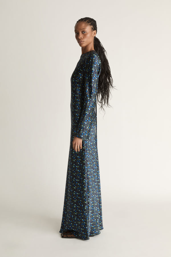 Woman wearing a long-sleeve dress with a pattern on a white background