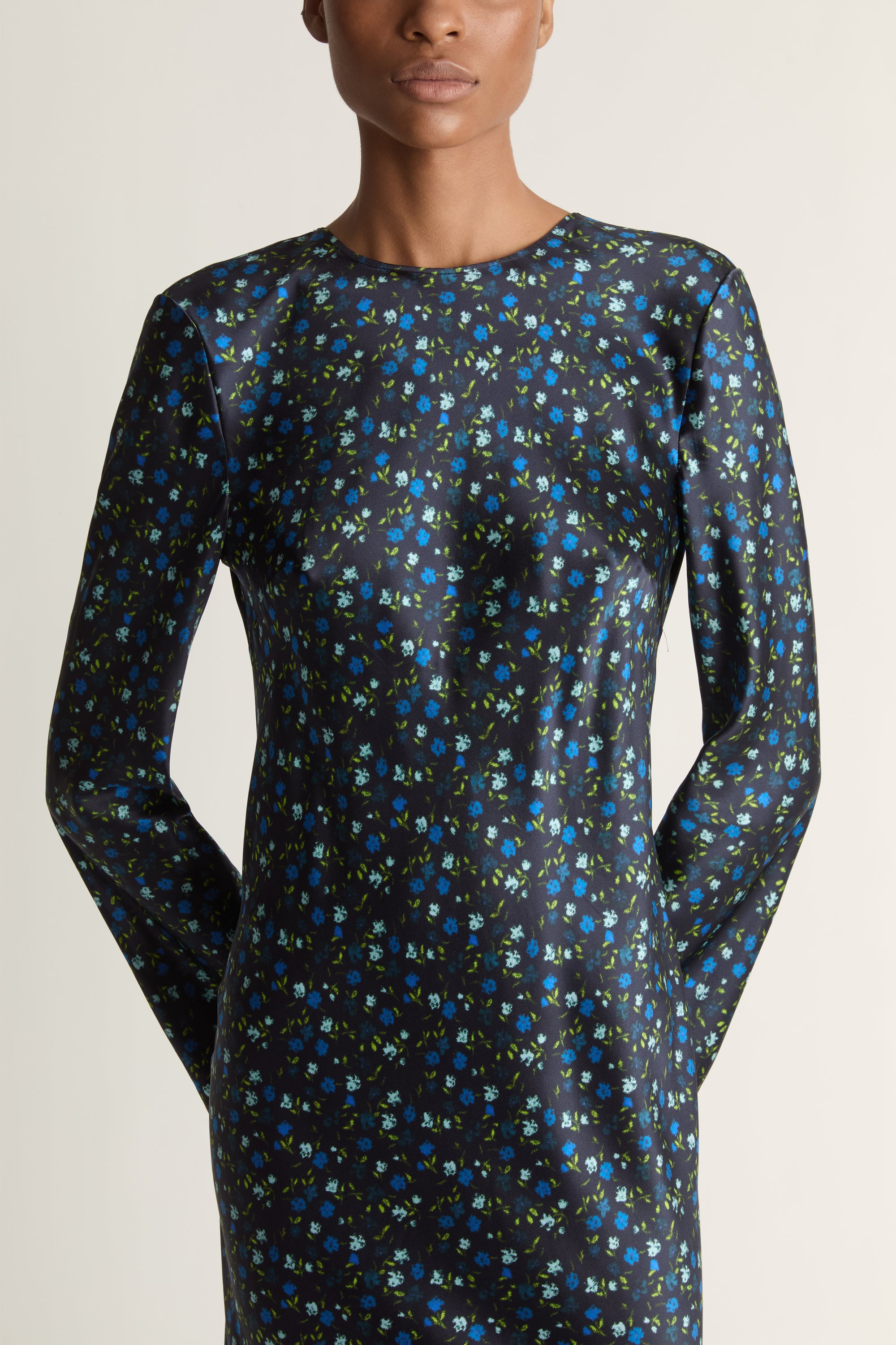Woman wearing a long-sleeve dress with a pattern on a white background