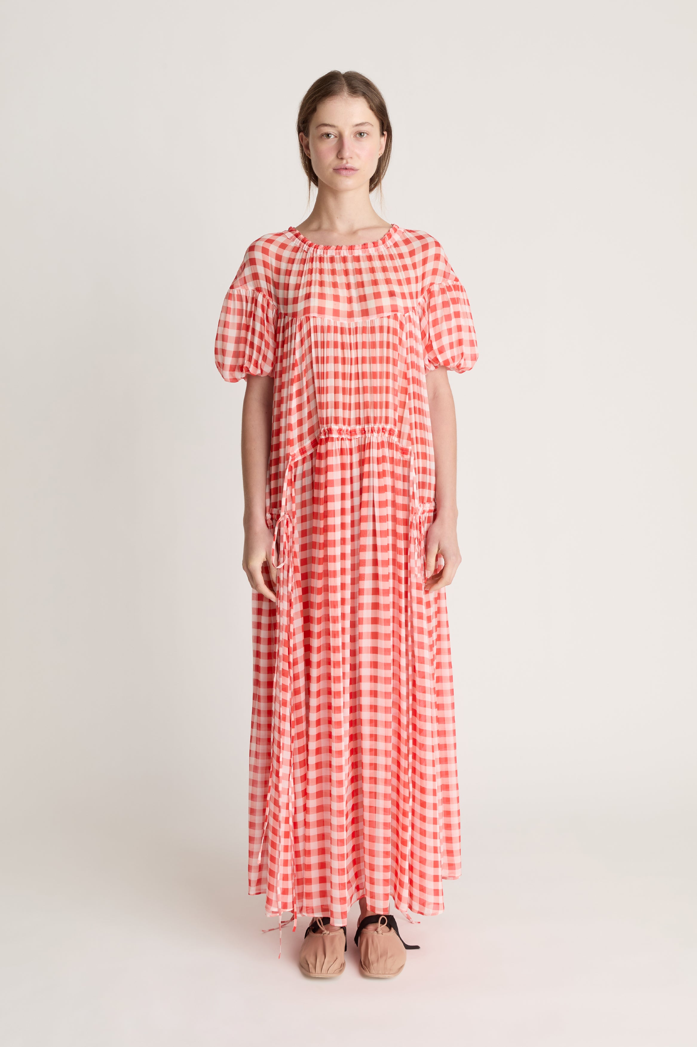 Woman wearing a red and white checkered dress on a white background
