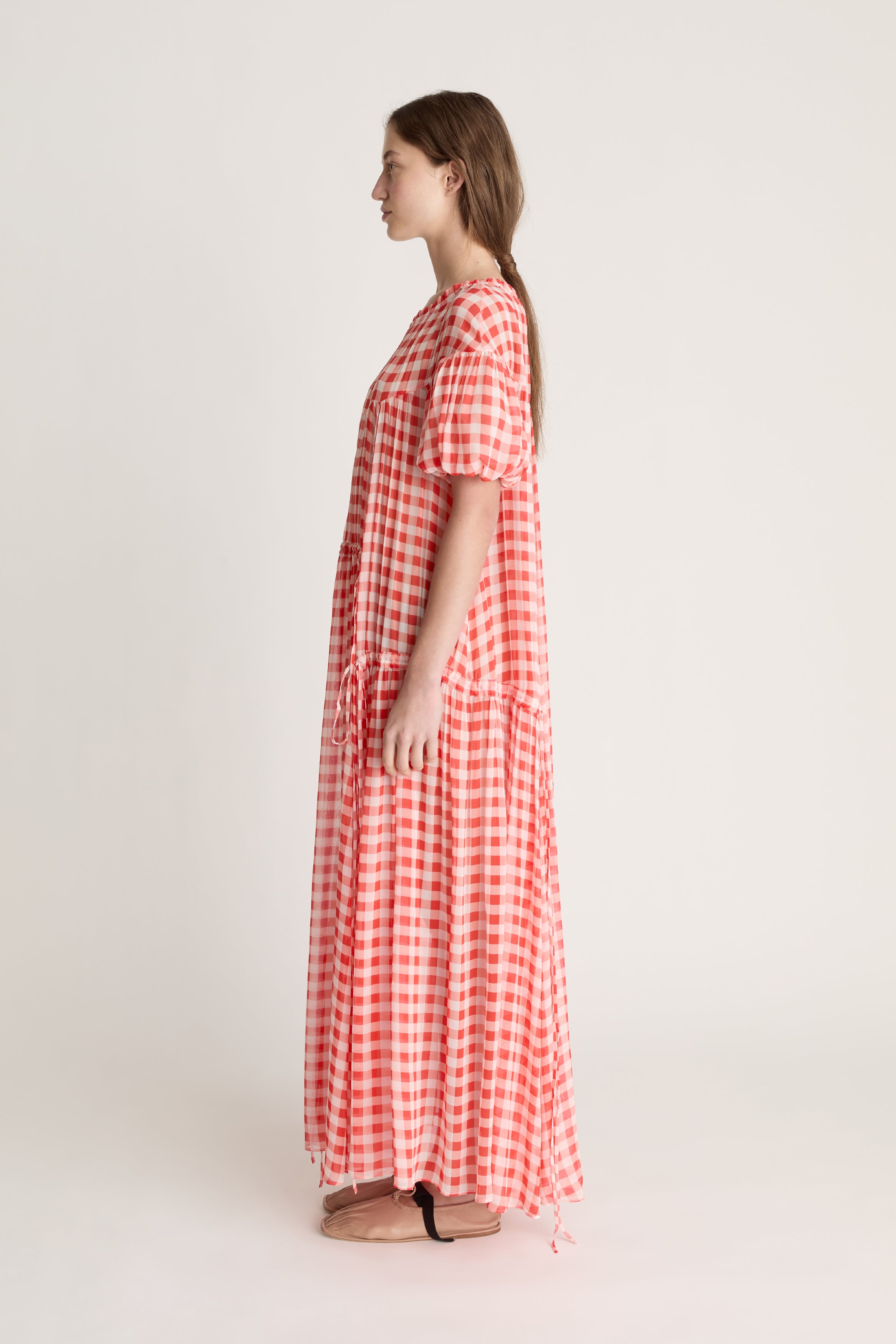 Woman wearing a red and white checkered dress on a white background