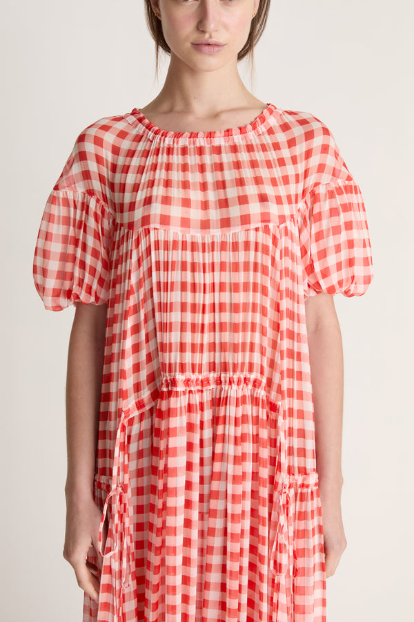 Red and white checkered dress worn by a person on a plain background