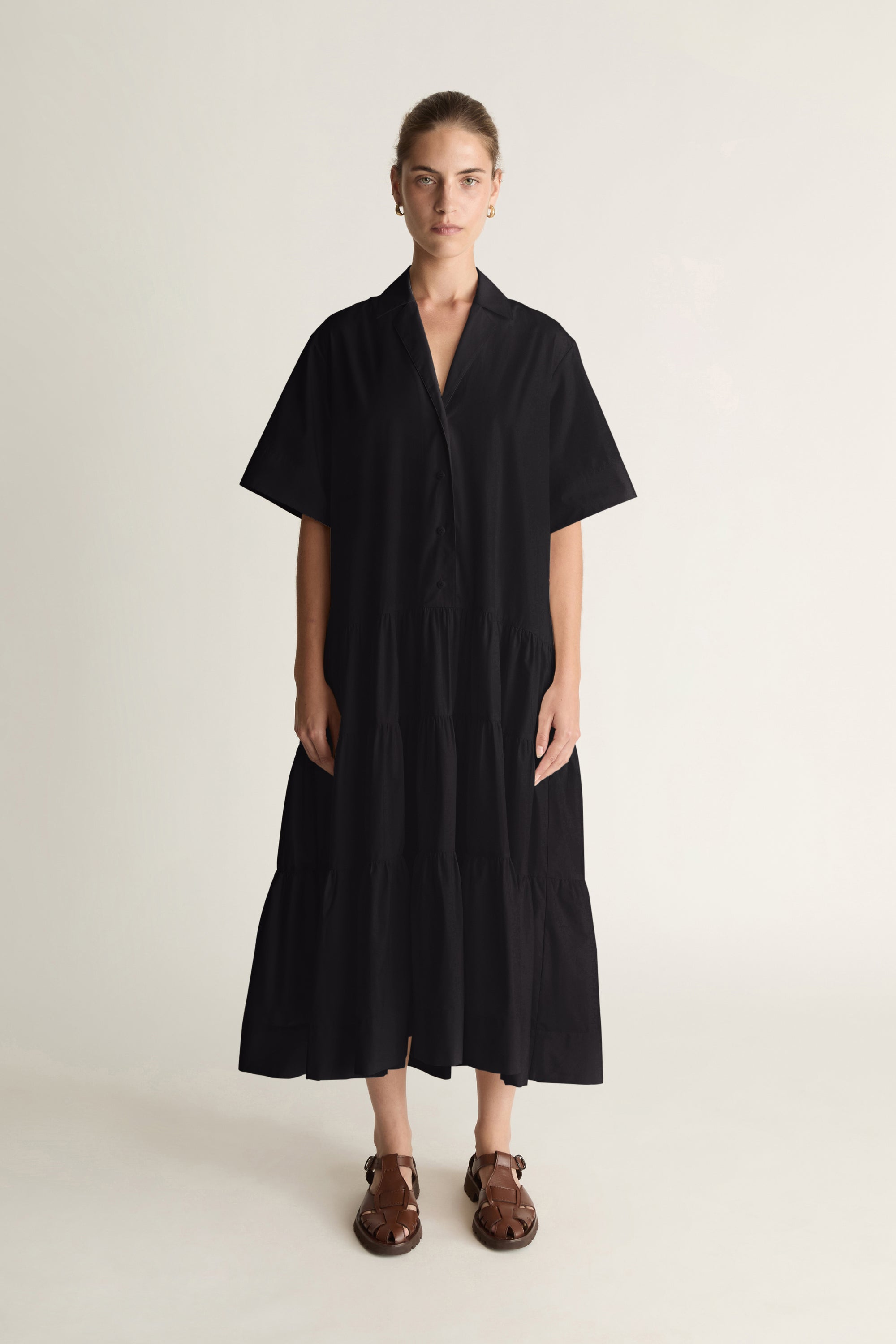 Person wearing a black dress on a plain background