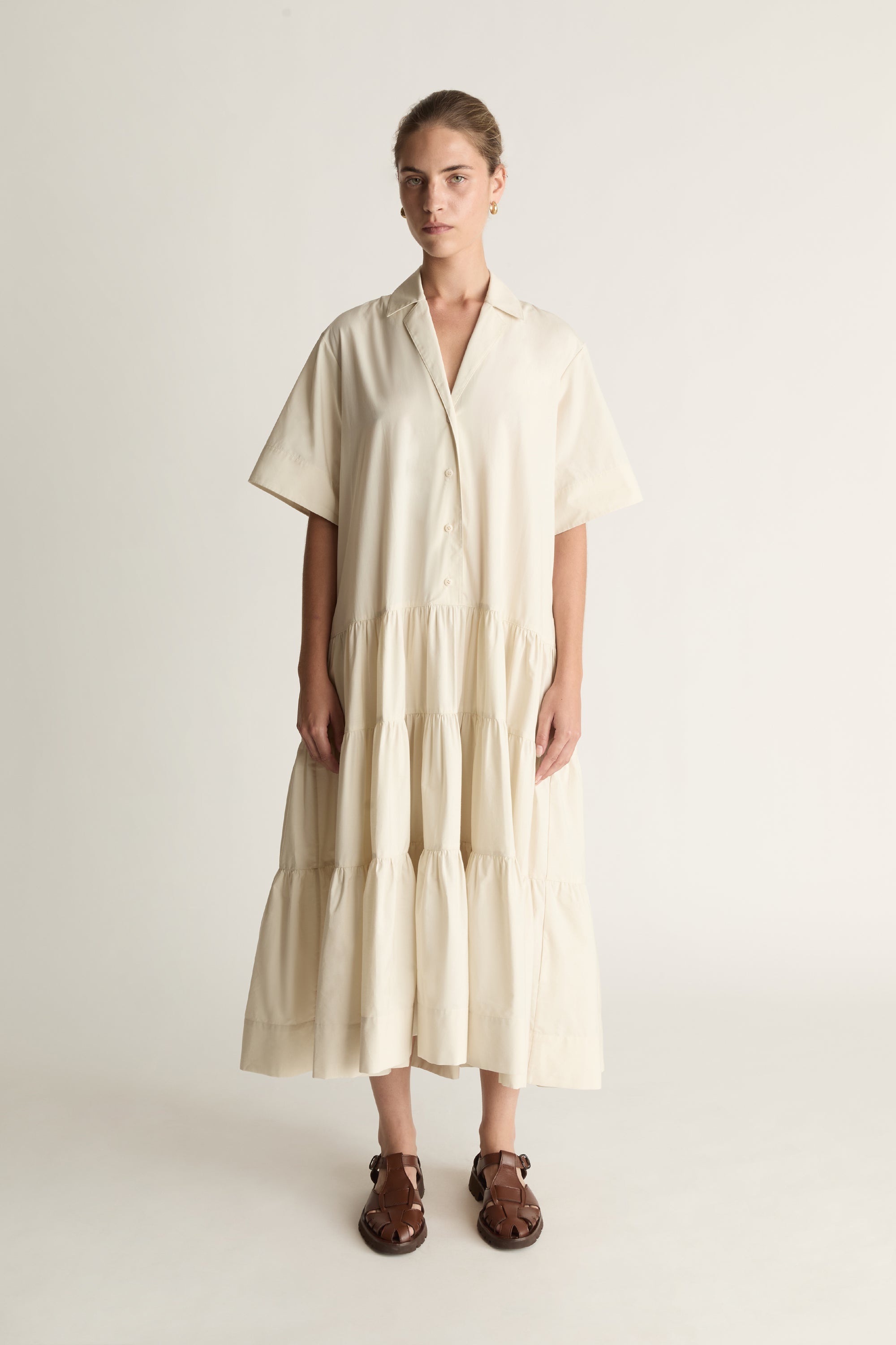 Woman wearing a beige dress against a white background