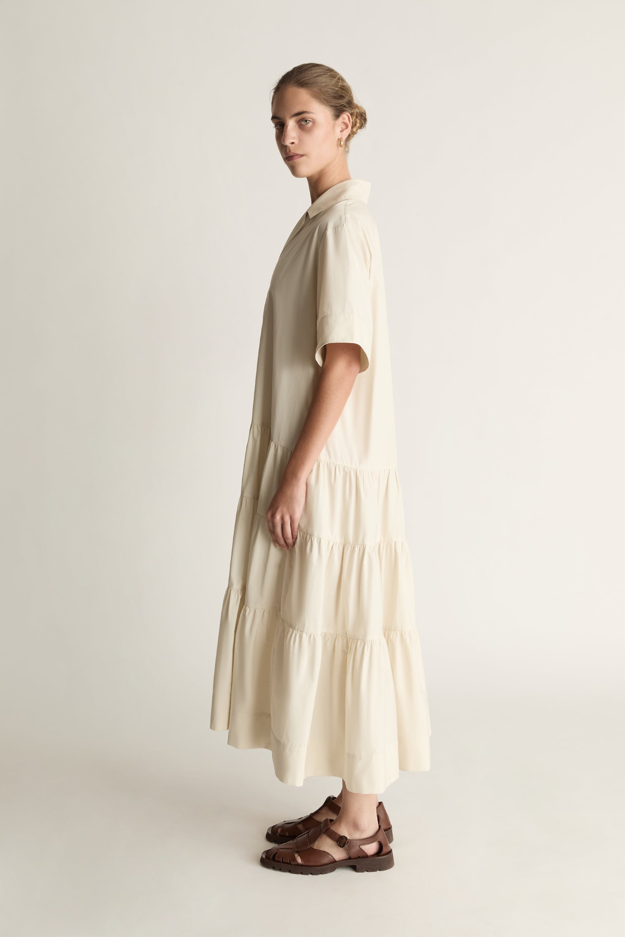 Woman wearing a beige dress against a white background