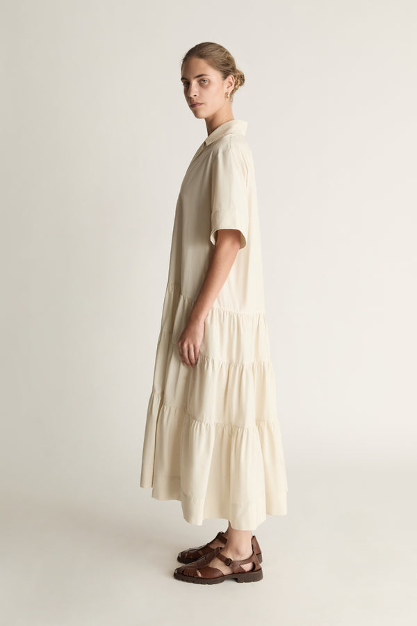 Woman wearing a beige dress against a white background