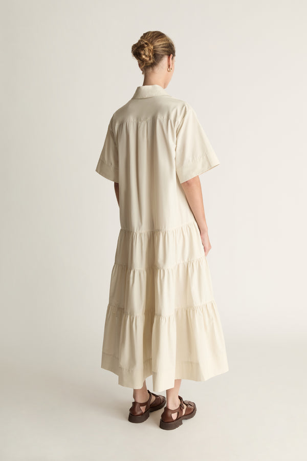 Woman wearing a beige dress against a white background