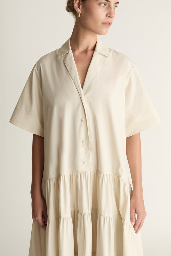 Woman wearing a beige dress against a white background
