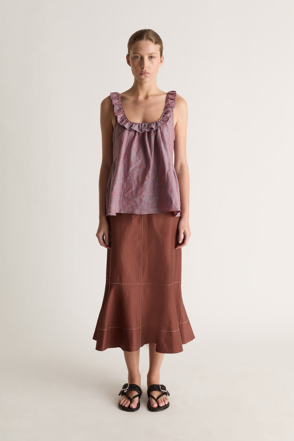 Front view of a woman wearing a plum check cami top with a brown flared midi skirt against a white studio background
