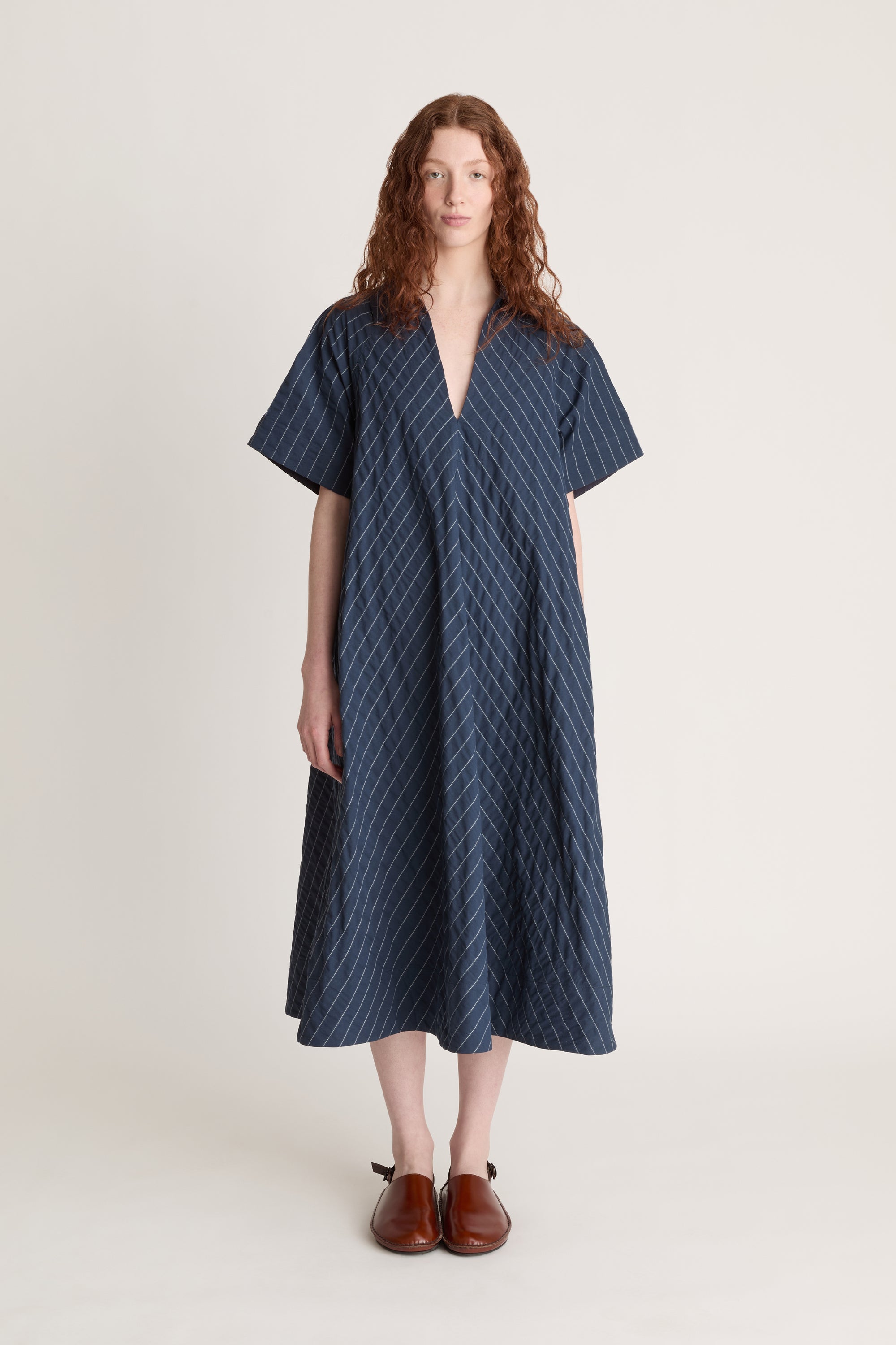 Woman wearing a blue striped dress on a white background