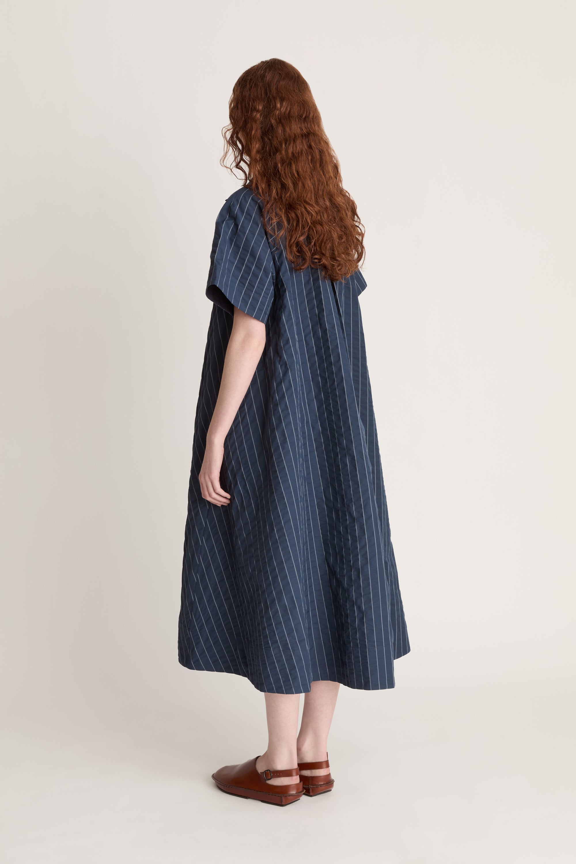 Woman wearing a blue striped dress on a white background