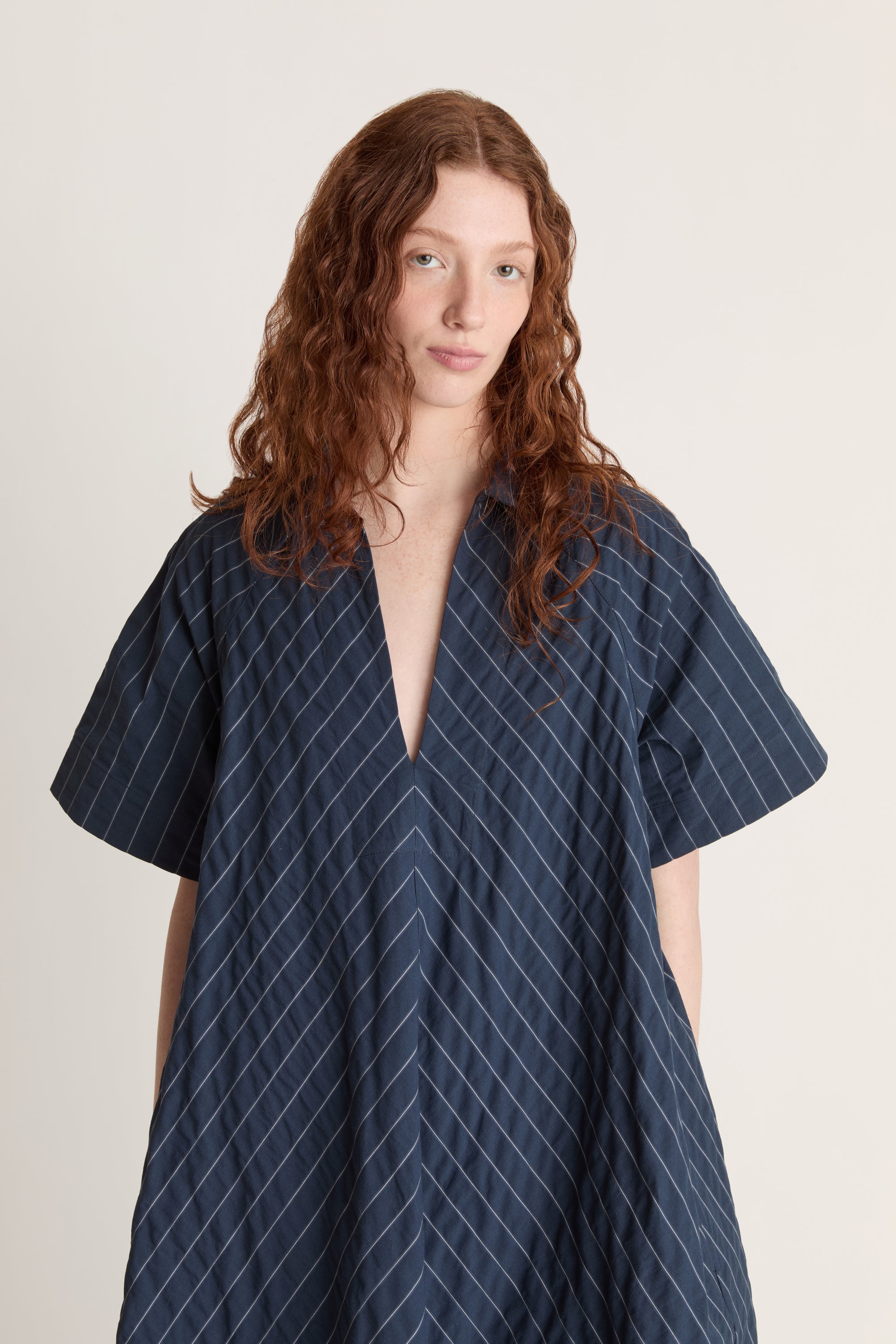 Woman wearing a blue striped dress on a white background