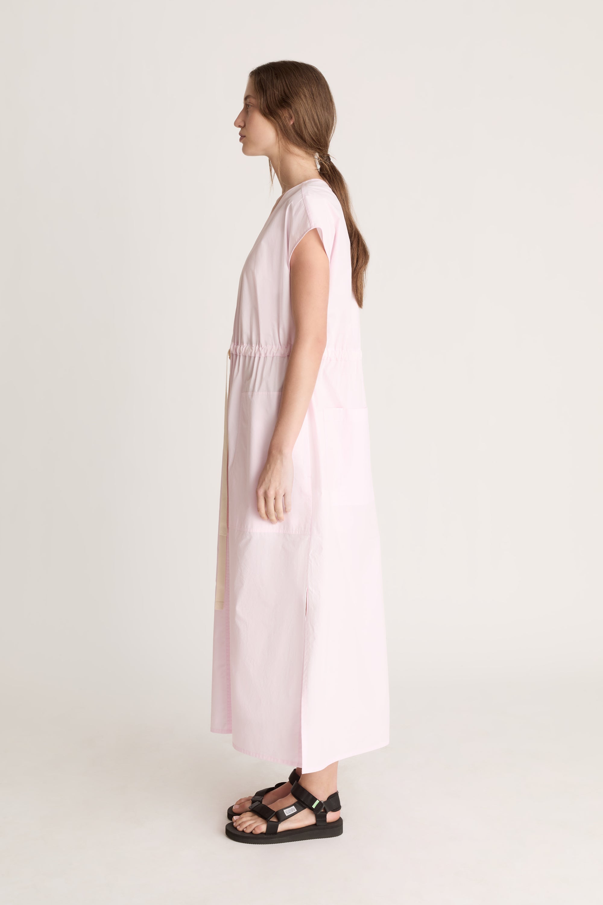 Woman wearing a light pink dress on a white background