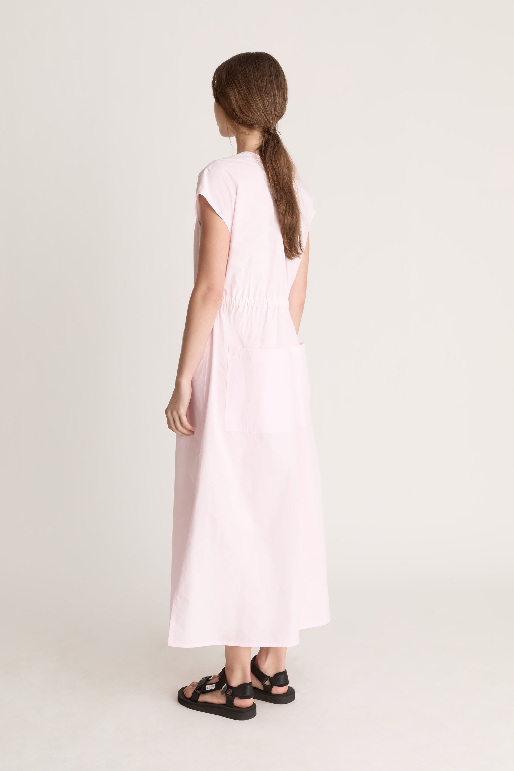 Woman wearing a light pink dress on a white background
