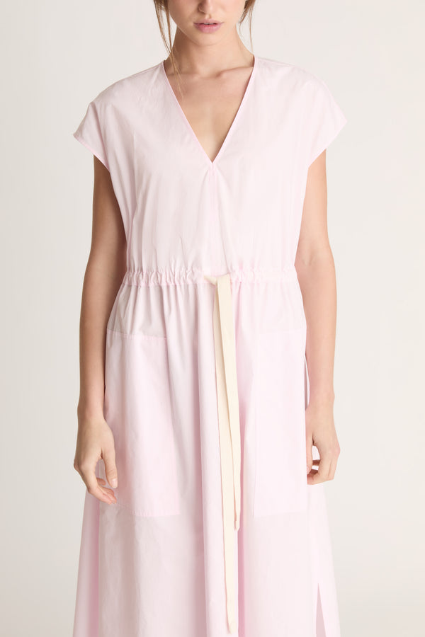 Woman wearing a light pink dress on a white background