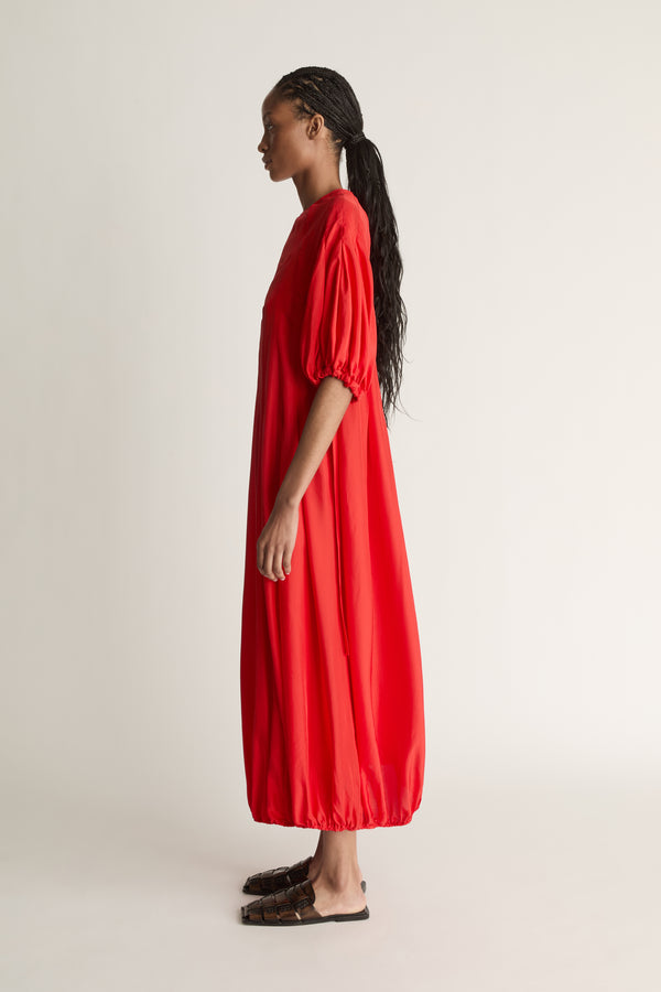 Person wearing a red dress on a white background