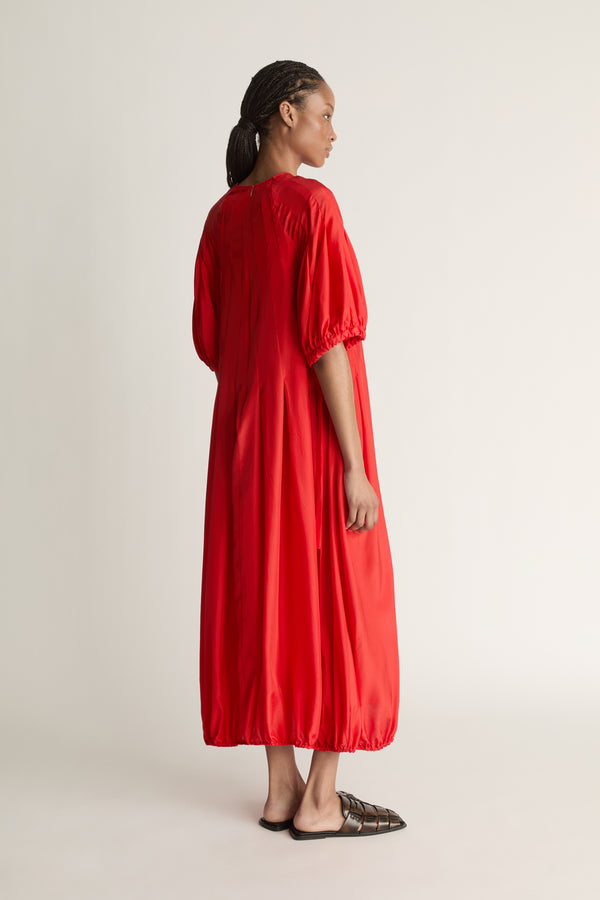 Person wearing a red dress on a white background