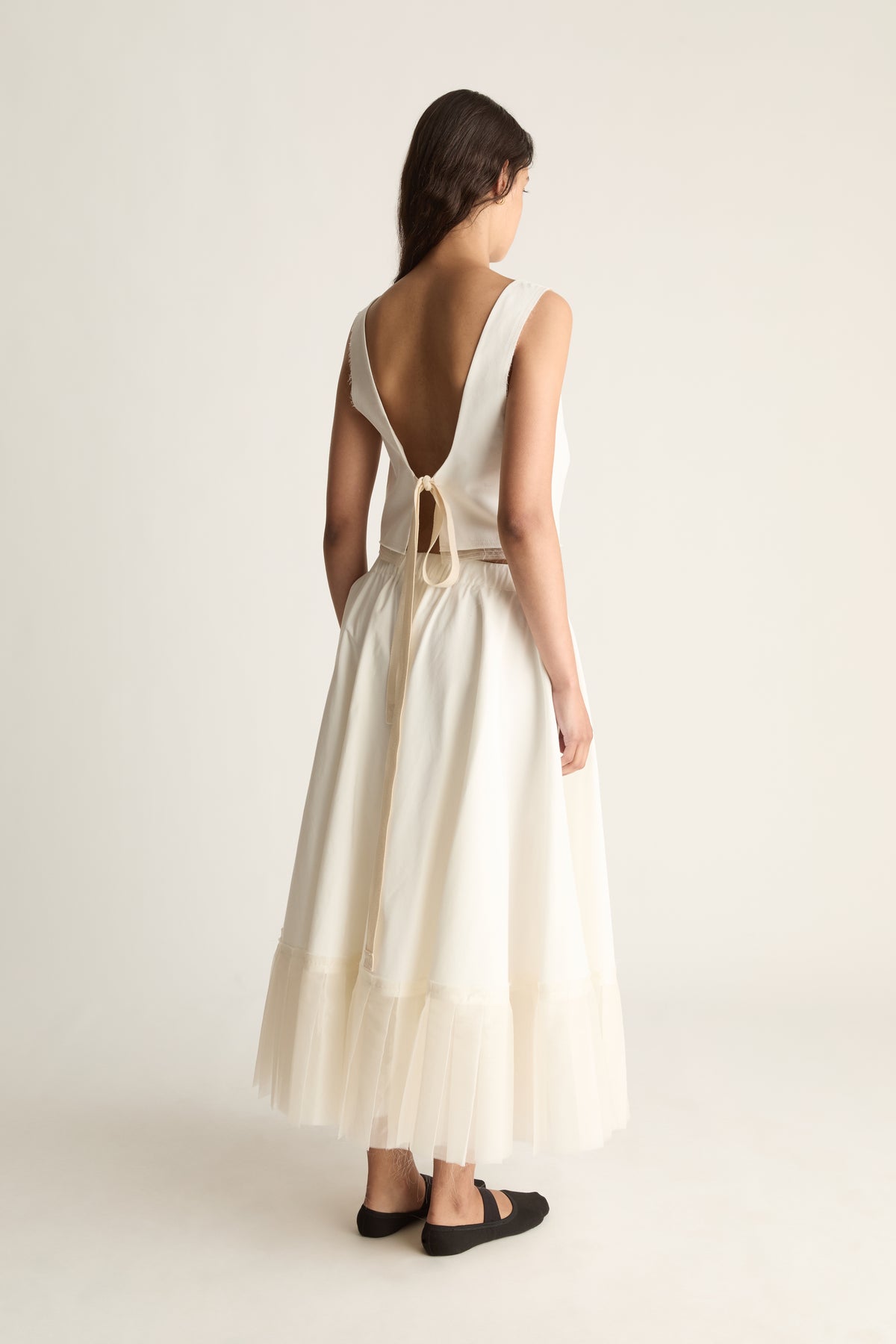 Back view of a full cream maxi skirt with an elasticated waist and a sheer layered hem.