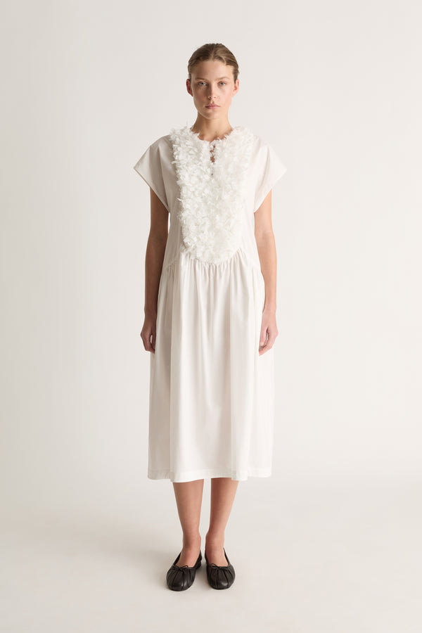 Front view of a white midi dress with cap sleeves, a ruffled bib front and gathered dropped waist.
