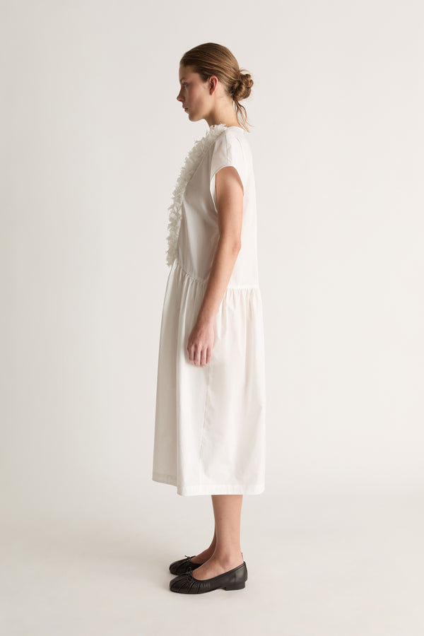 Side view of a white midi dress with cap sleeves, a ruffled front and gathered skirt.