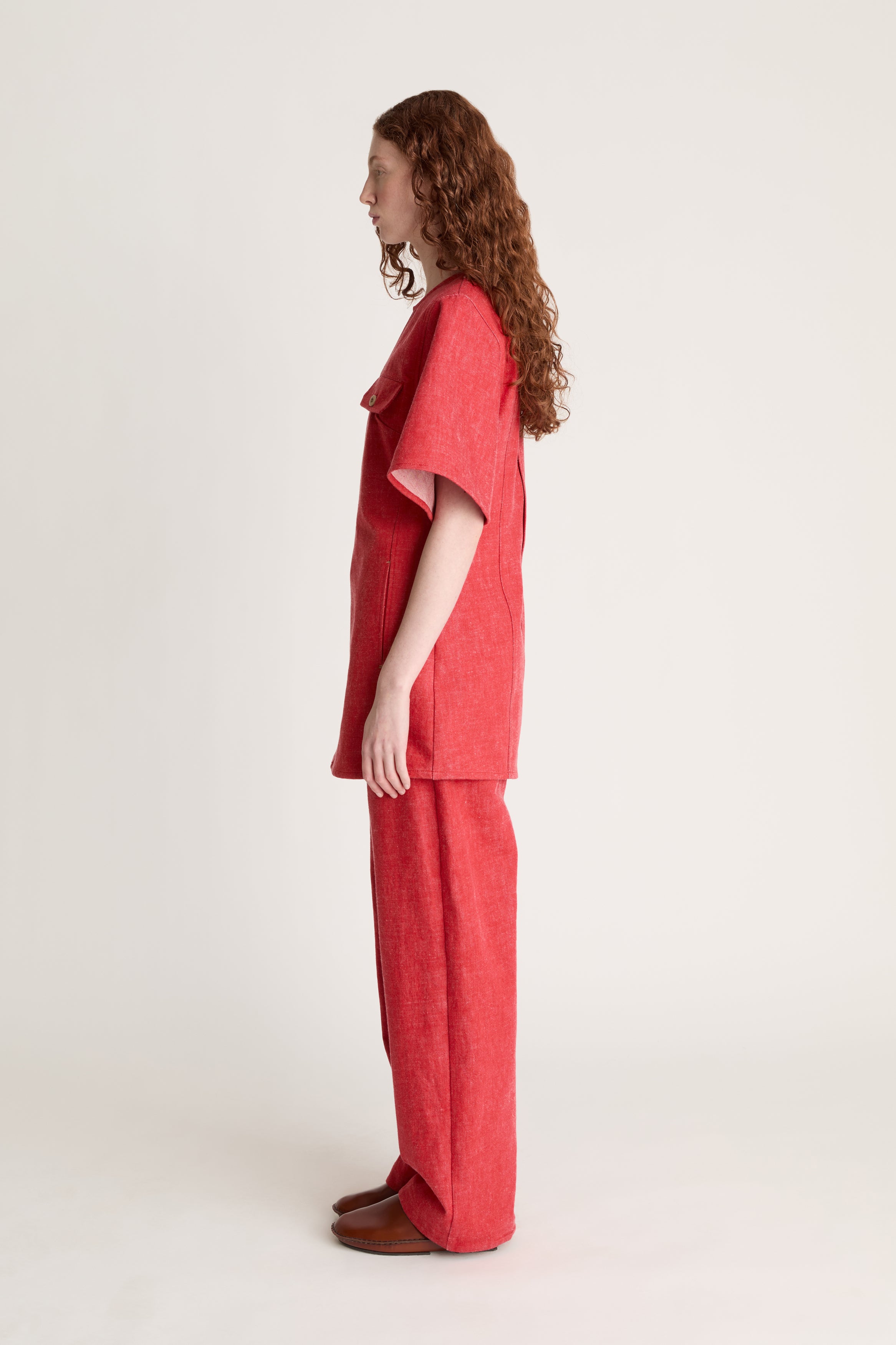 Person wearing a reddress and red pants on a white background