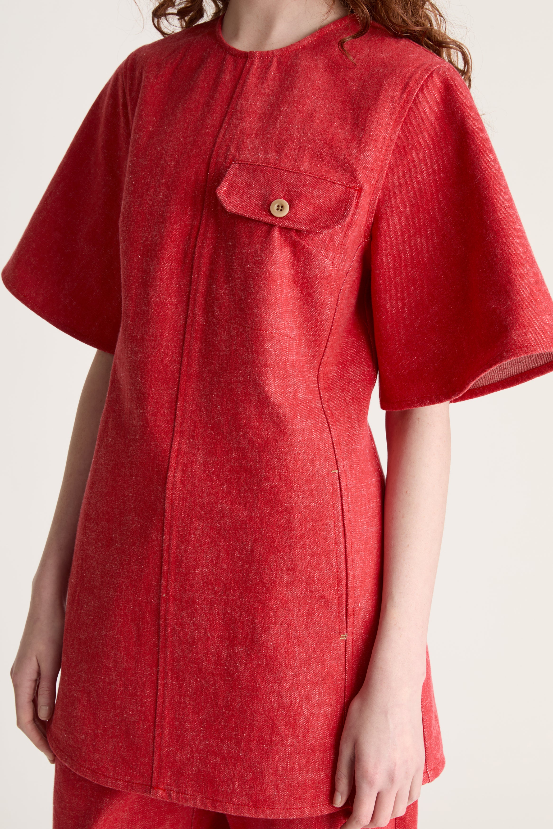 Person wearing a reddress and red pants on a white background