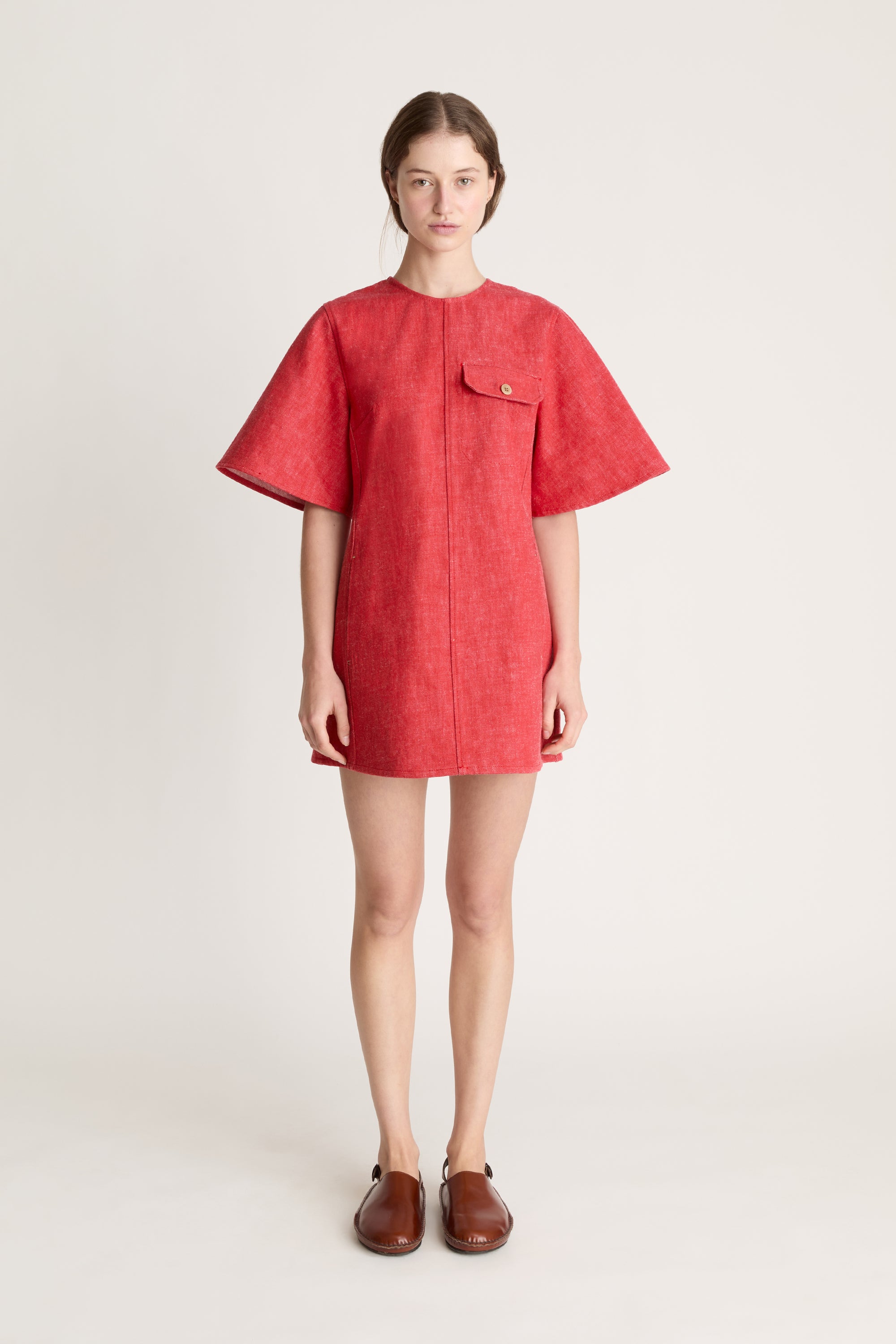 Person wearing a reddress and red pants on a white background