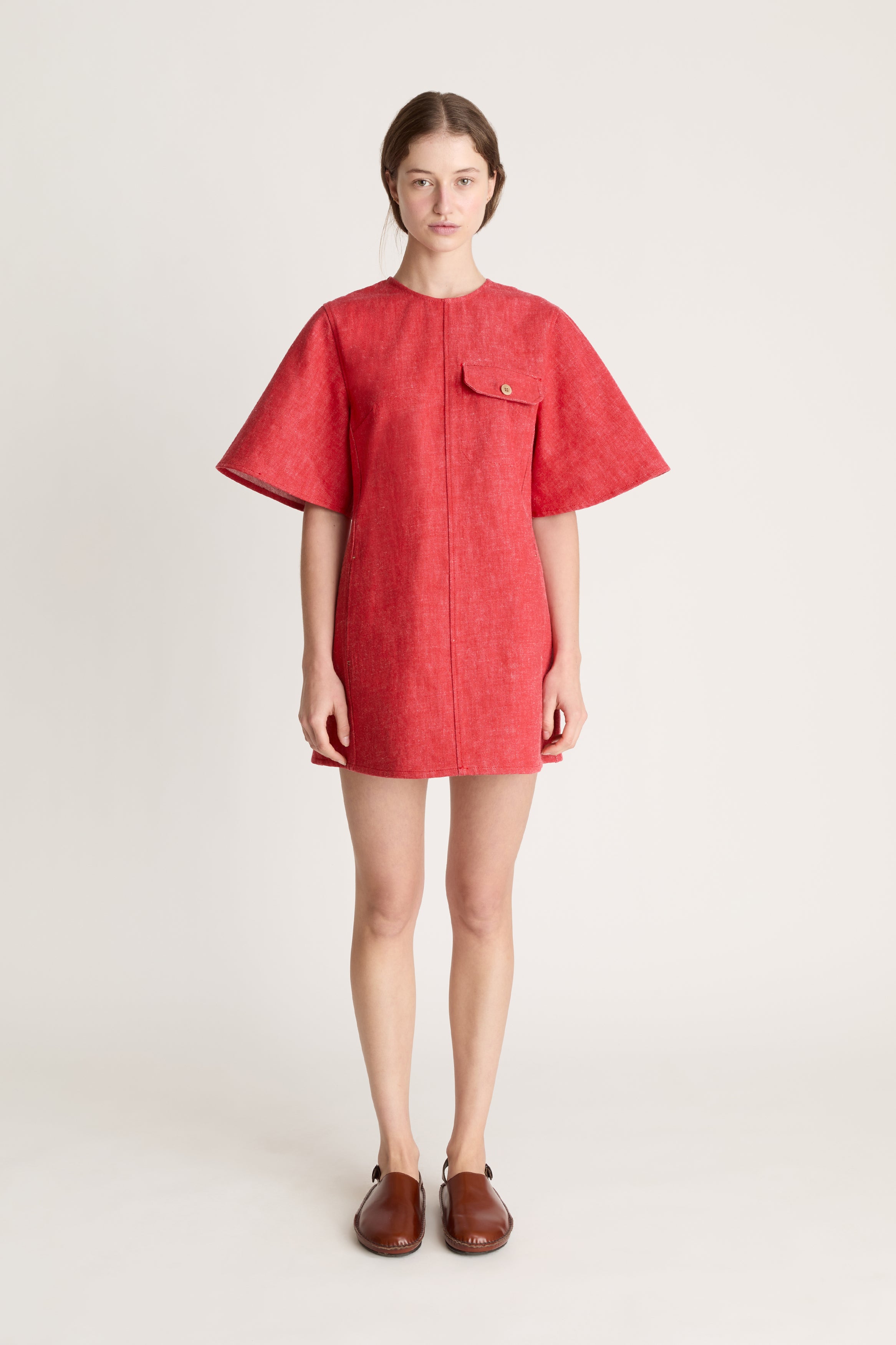 Person wearing a reddress and red pants on a white background