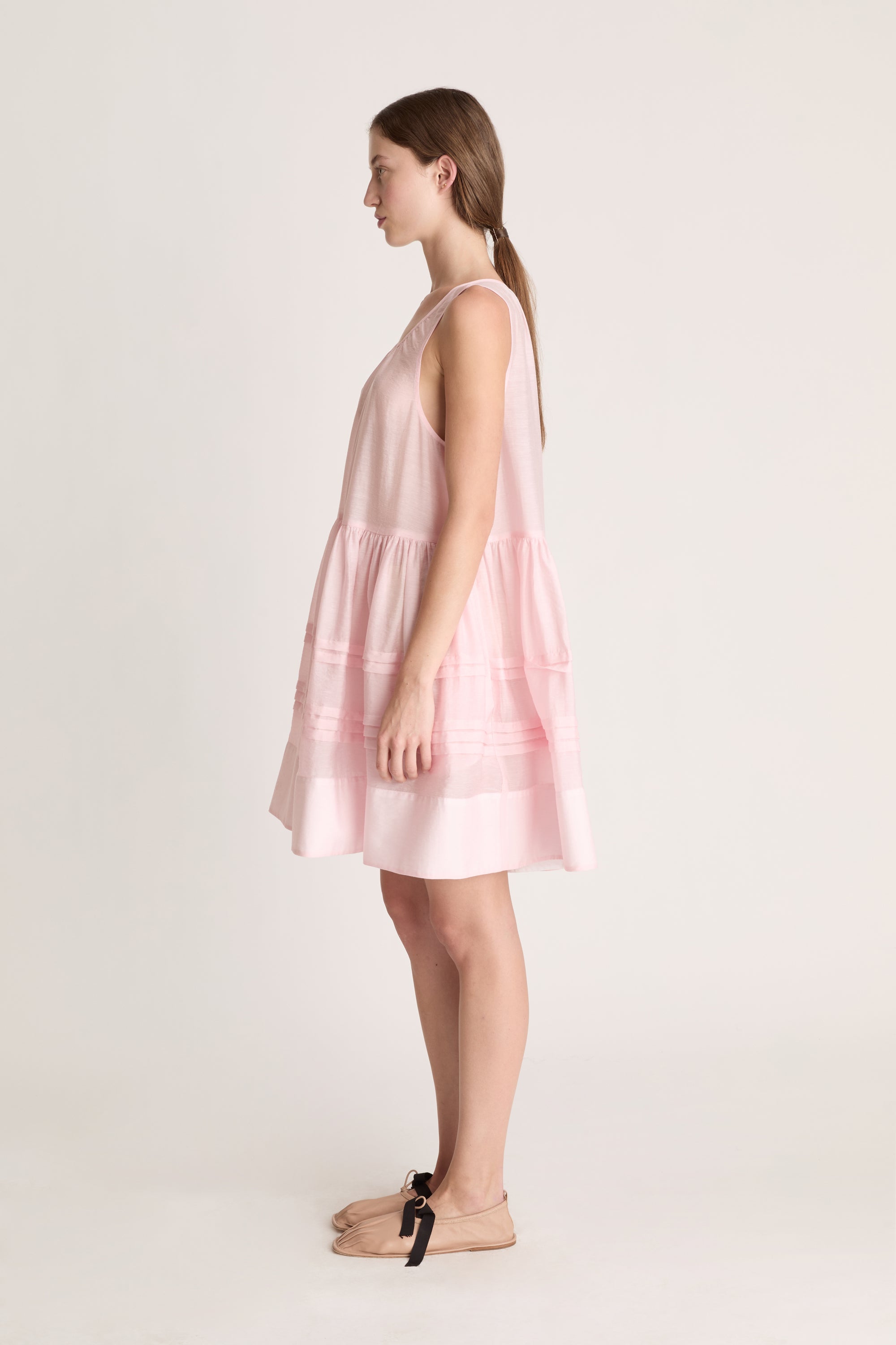 Woman wearing a pink dress against a white background