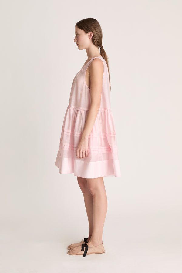 Woman wearing a pink dress against a white background