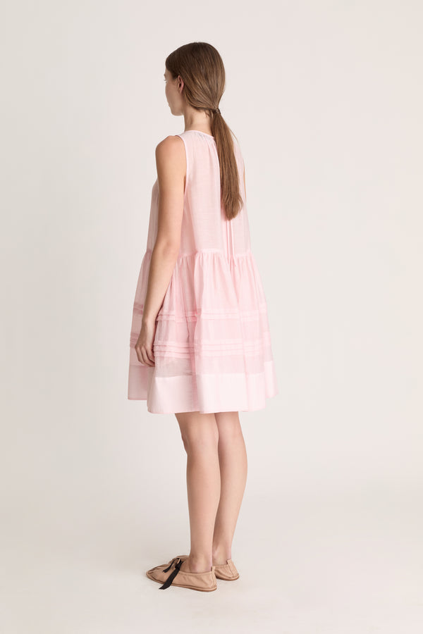 Woman wearing a pink dress against a white background
