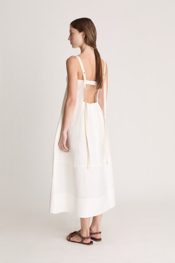 Woman wearing a white dress on a plain background