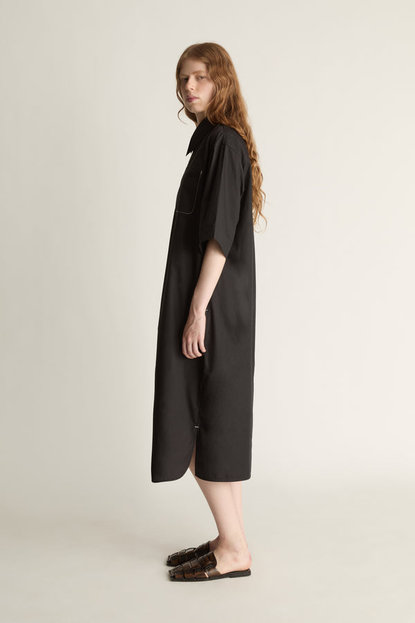 Woman wearing a black dress on a plain background