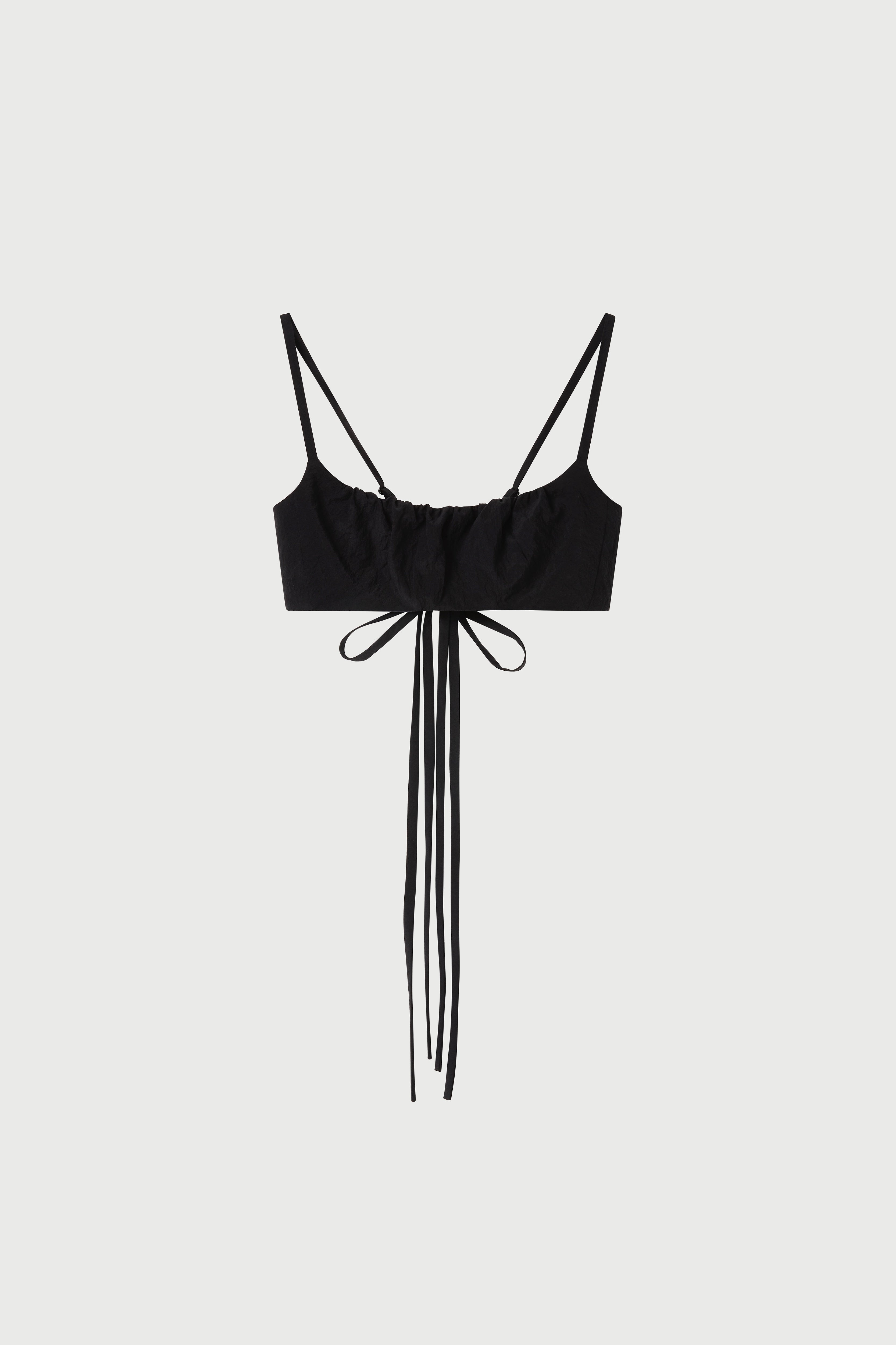 Black strappy top with fringe details on a white background