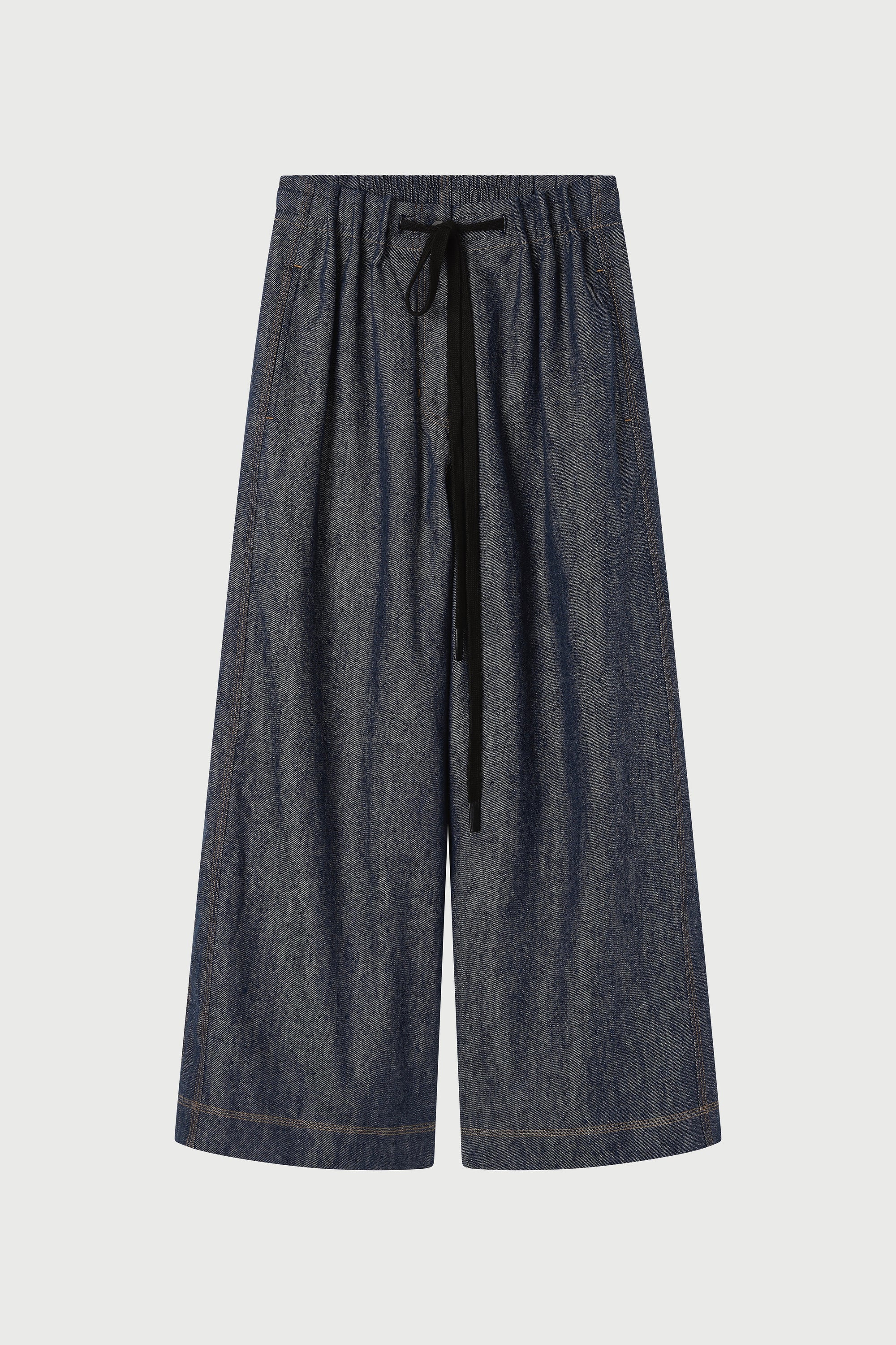 Dark blue denim pants with a drawstring on a light gray background