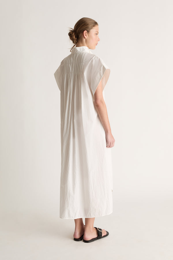 Back view of a white midi shirt dress with pin tucks across the back yoke and wide cap sleeves.