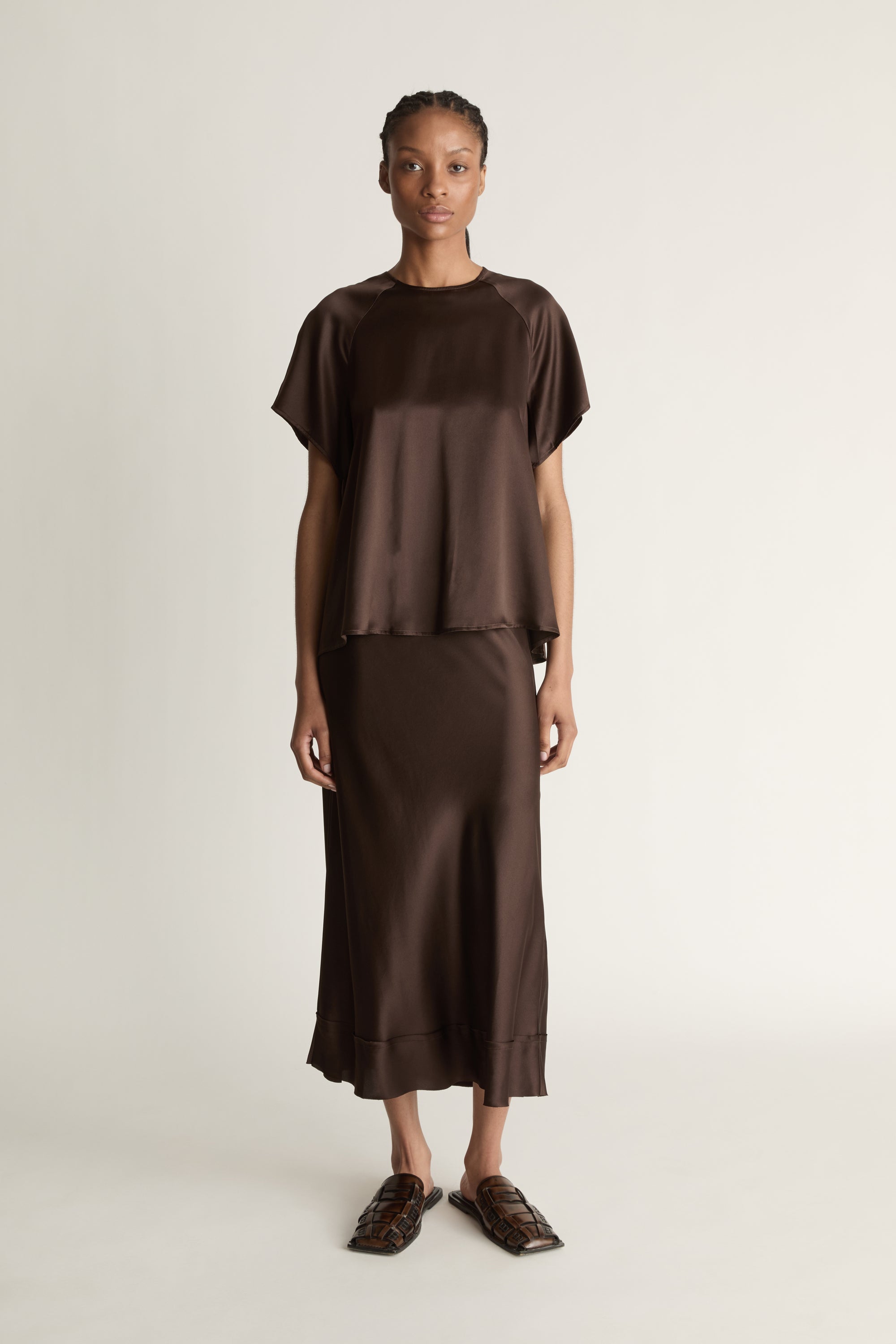 Woman wearing a brown outfit on a plain background