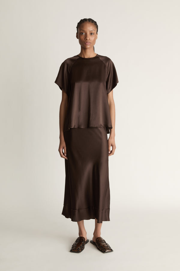 Woman wearing a brown outfit on a plain background