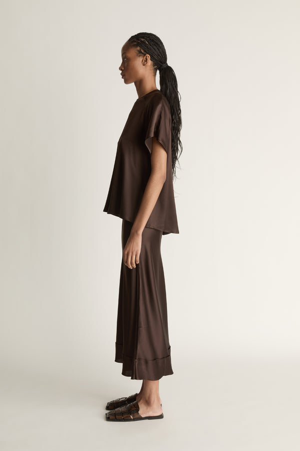 Woman wearing a brown outfit on a plain background
