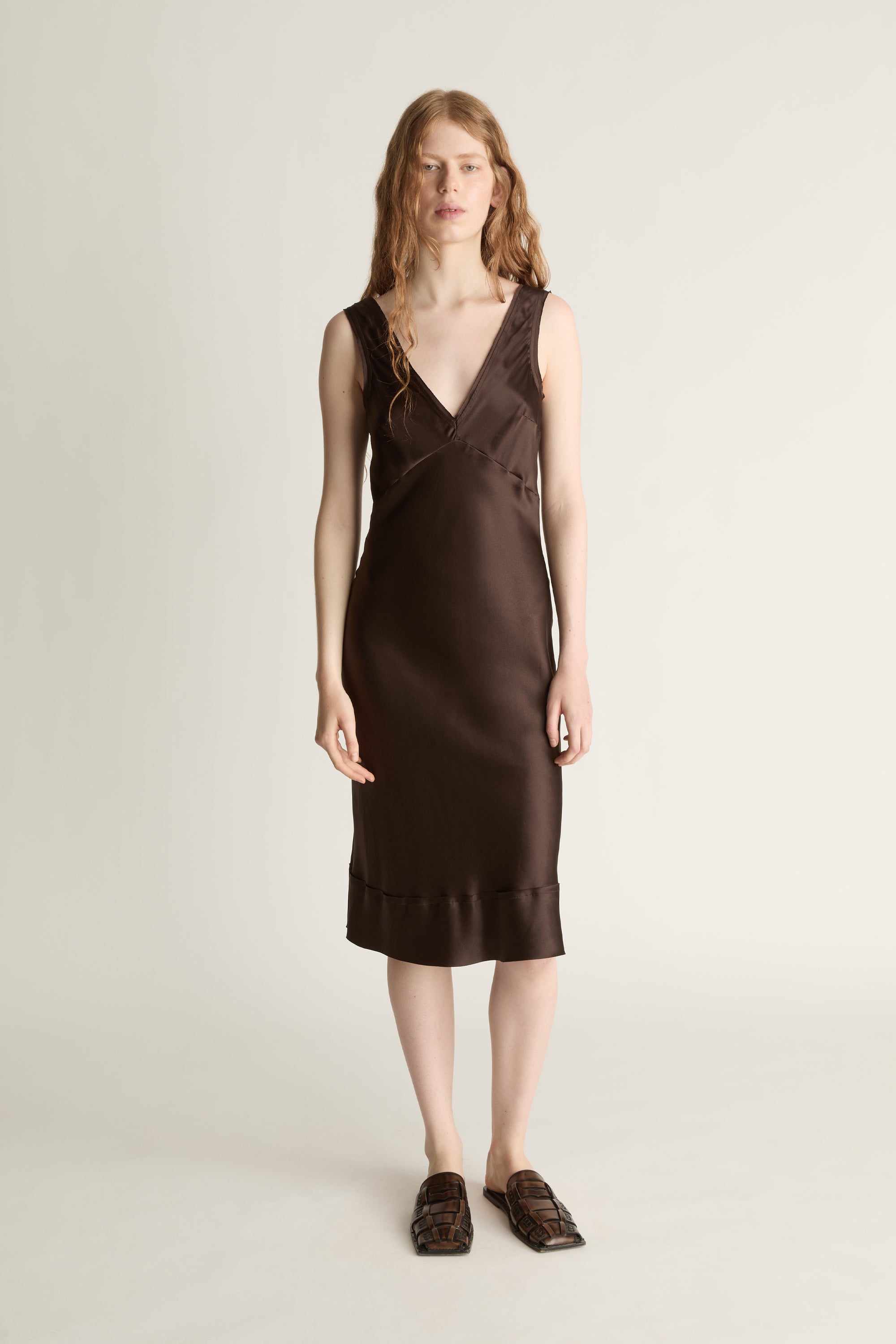 Woman wearing a brown dress on a plain background