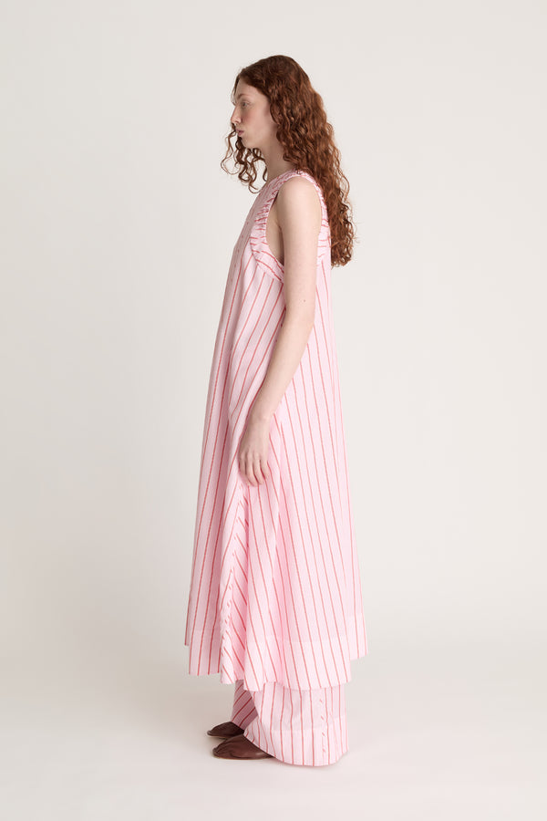 Woman wearing a pink and white striped dress on a white background